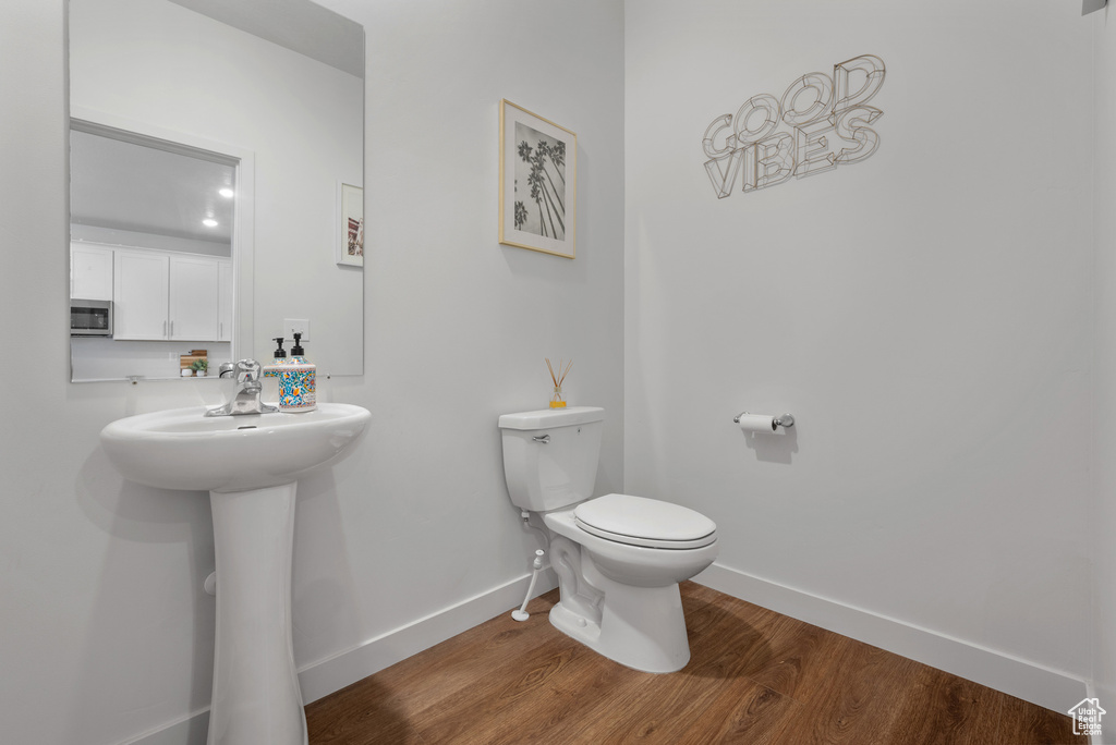 Bathroom featuring wood finished floors and toilet