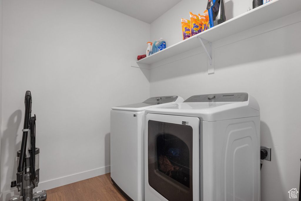 Laundry area featuring washing machine and clothes dryer and wood finished floors