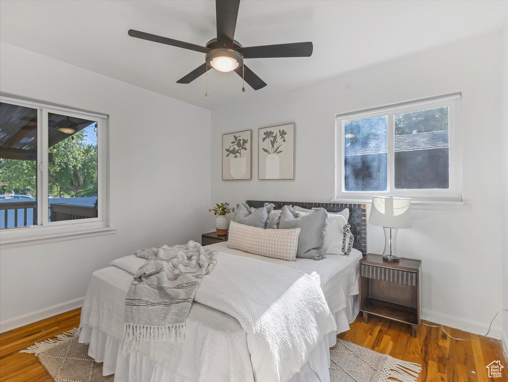 Bedroom featuring multiple windows, wood finished floors, and ceiling fan
