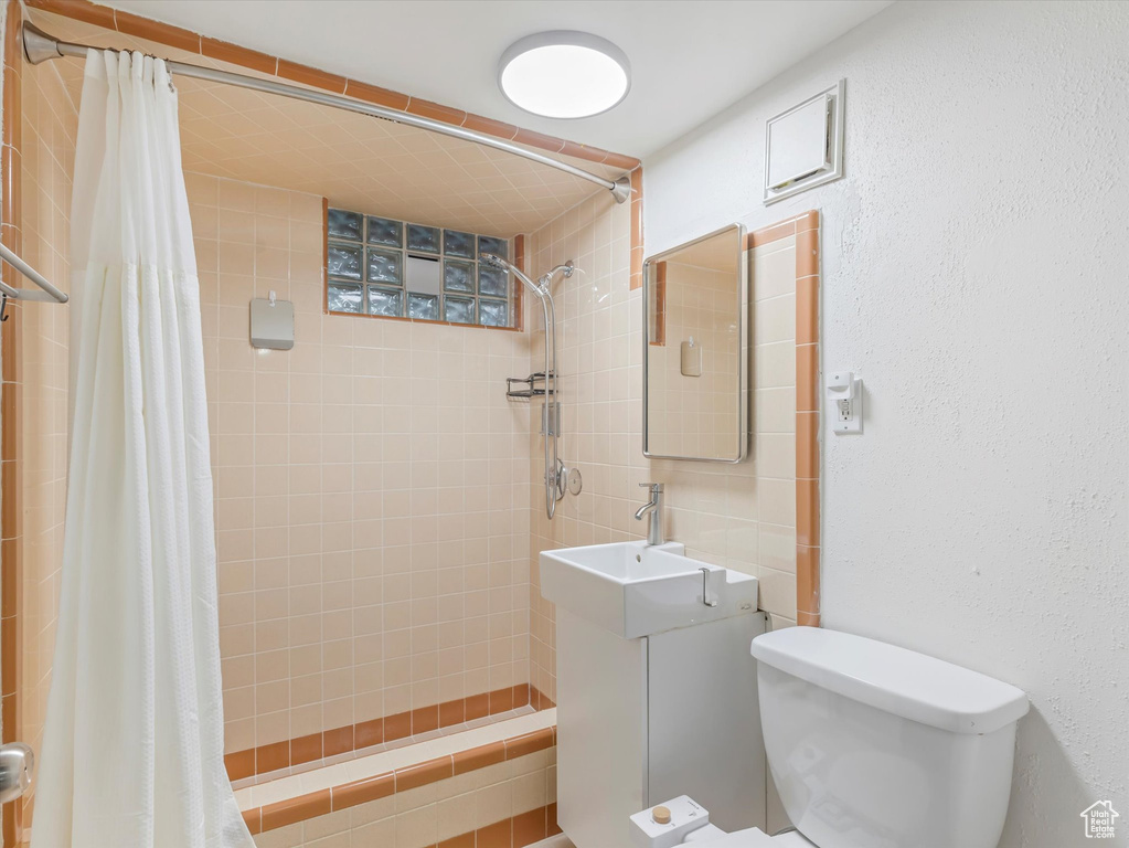 Bathroom with tiled shower and vanity