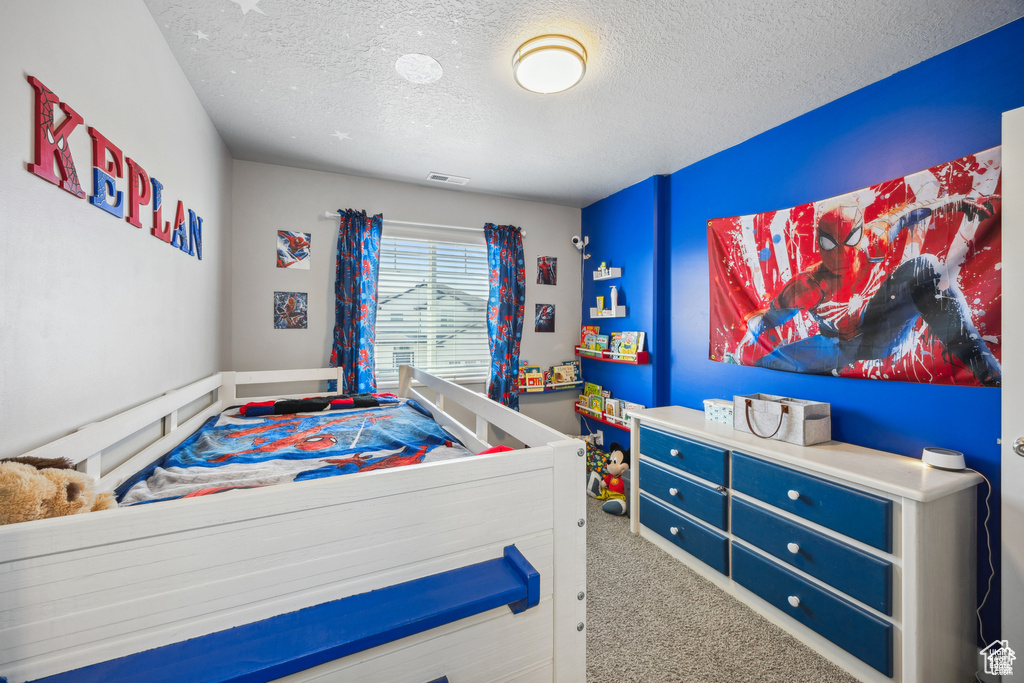 Bedroom with carpet and a textured ceiling
