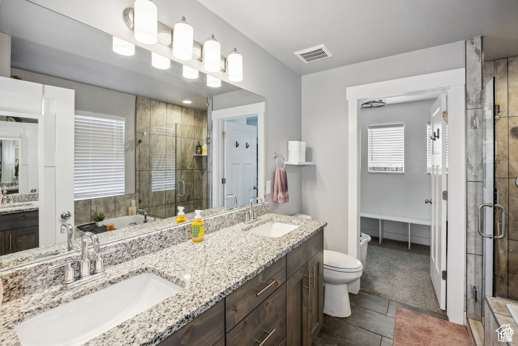 Full bath featuring a shower stall, double vanity, and a bidet