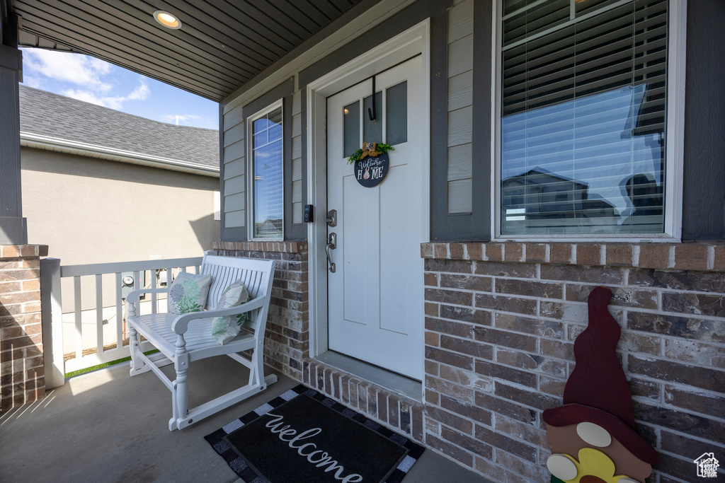 Property entrance with a porch and brick siding