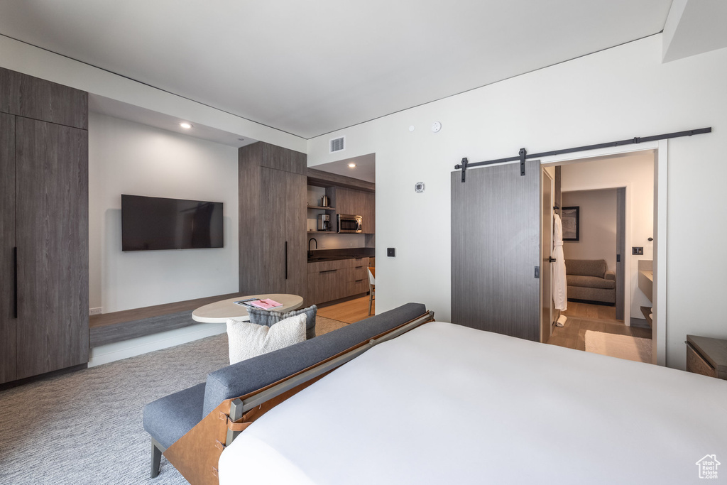 Bedroom with a barn door and recessed lighting