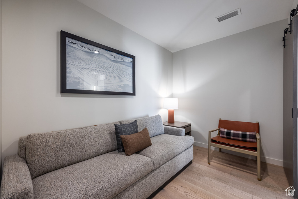 Living area with a barn door and light wood-type flooring