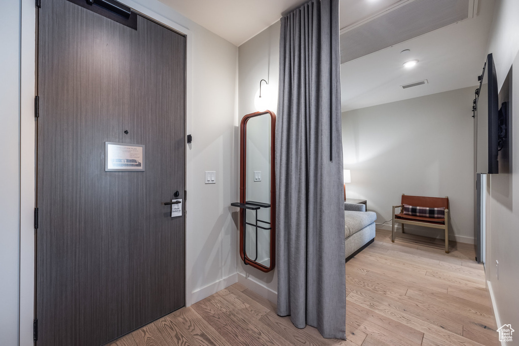 Foyer entrance with light wood-style floors and baseboards