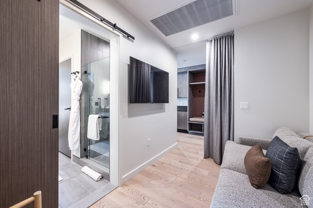 Hallway featuring a barn door and light wood-style floors