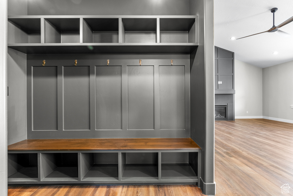 Mudroom featuring wood finished floors, a large fireplace, and vaulted ceiling