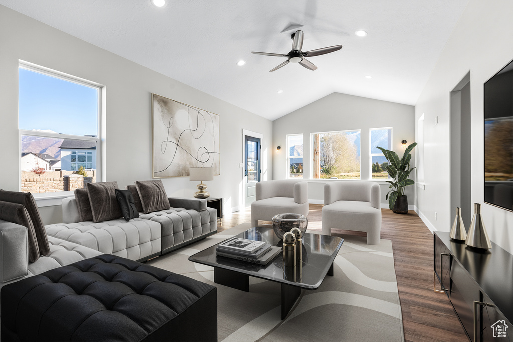 Living room with ceiling fan, plenty of natural light, wood finished floors, lofted ceiling, and recessed lighting