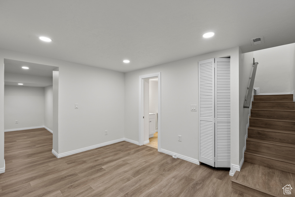 Basement featuring recessed lighting, light wood-style flooring, and stairs