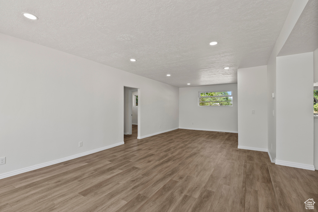 Spare room with recessed lighting, wood finished floors, and a textured ceiling