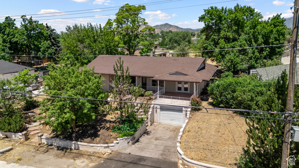 View of front of house featuring concrete driveway, french doors, a garage, a mountain view, and roof with shingles