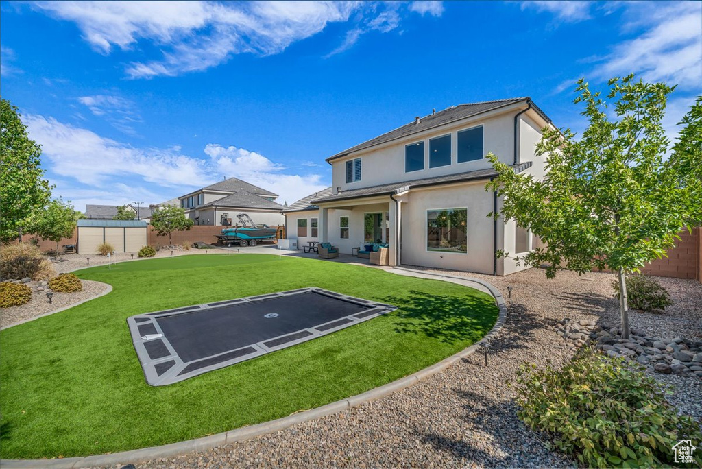 Back of property featuring an outdoor hangout area, stucco siding, a patio area, and a fenced backyard
