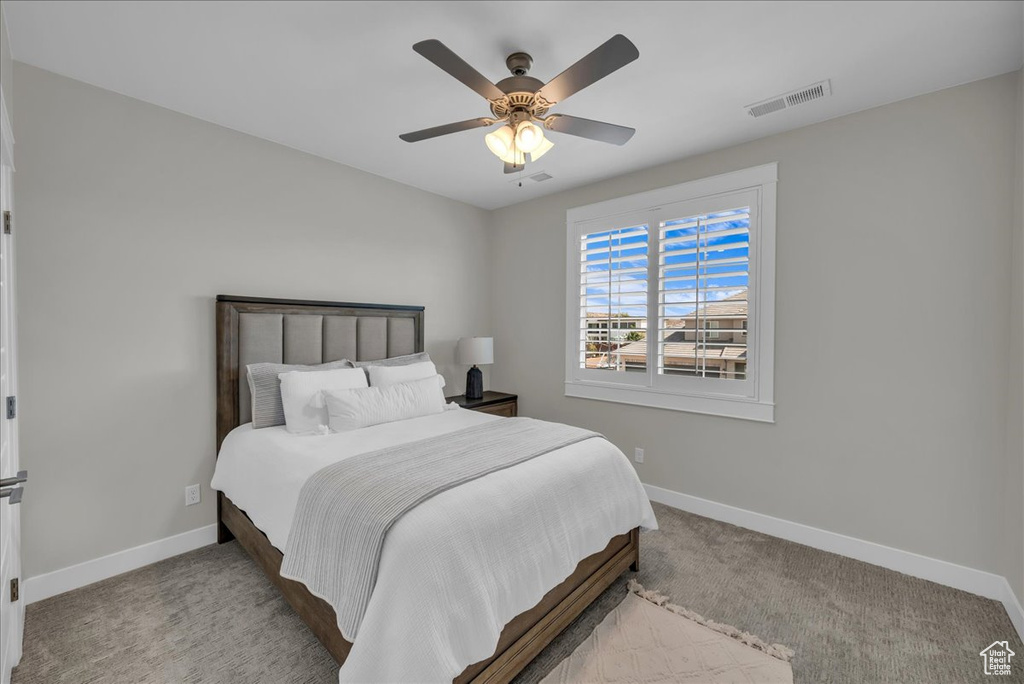 Carpeted bedroom featuring baseboards and a ceiling fan