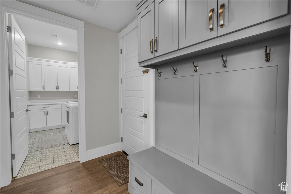 Mudroom with dark wood-type flooring, washer and clothes dryer, and recessed lighting