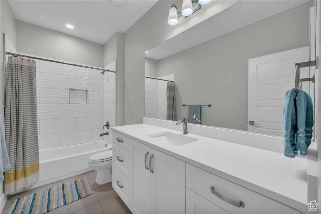 Bathroom featuring vanity, shower / bath combo, and tile patterned flooring