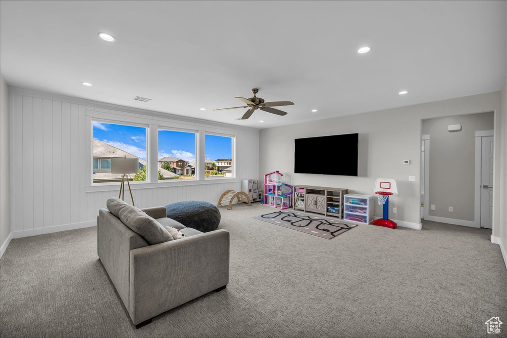 Carpeted living room with recessed lighting and a ceiling fan