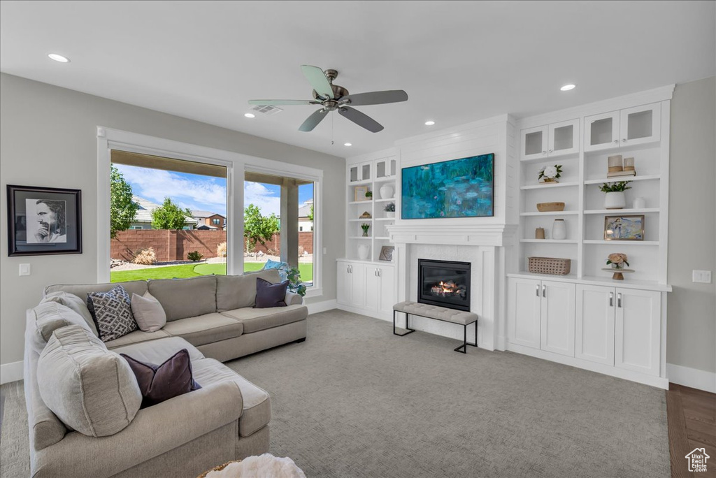Living room with recessed lighting, a glass covered fireplace, and a ceiling fan