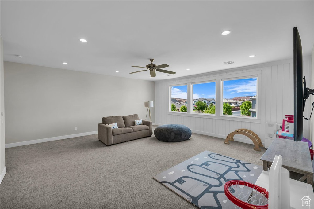 Carpeted living area with a ceiling fan and recessed lighting