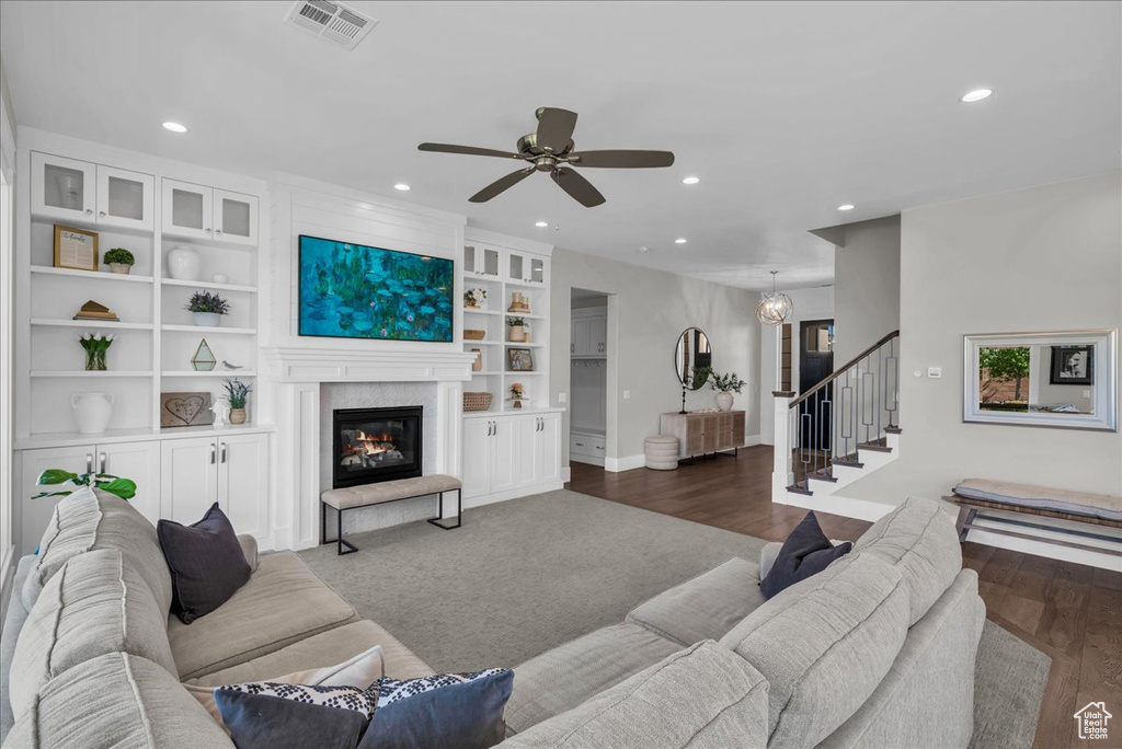 Living area with recessed lighting, stairway, ceiling fan, a glass covered fireplace, and built in features