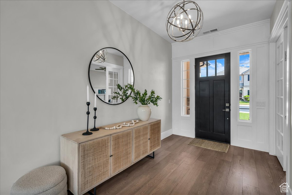 Entrance foyer featuring a chandelier and dark wood-style flooring