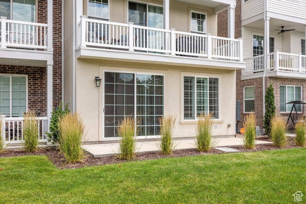 View of home's exterior featuring a yard, stucco siding, and a balcony
