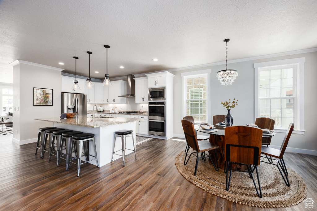 Dining area featuring ornamental molding, dark wood-style flooring, a chandelier, and recessed lighting