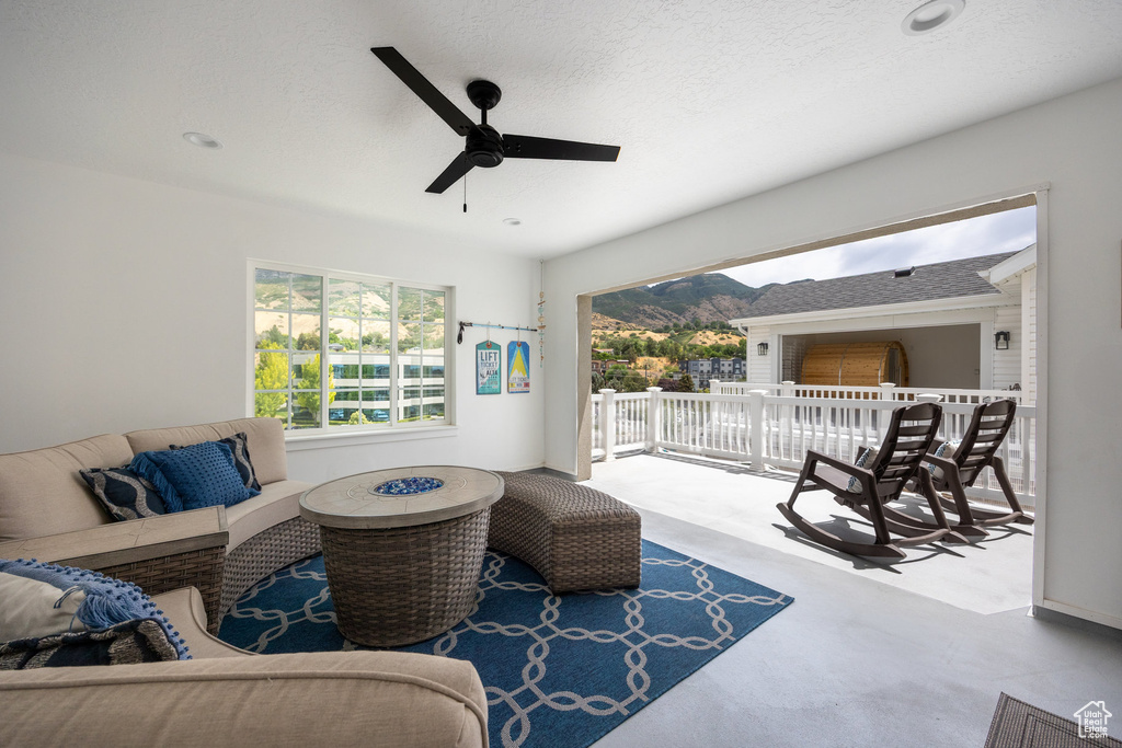 View of patio with an outdoor living space, a ceiling fan, and a mountain view