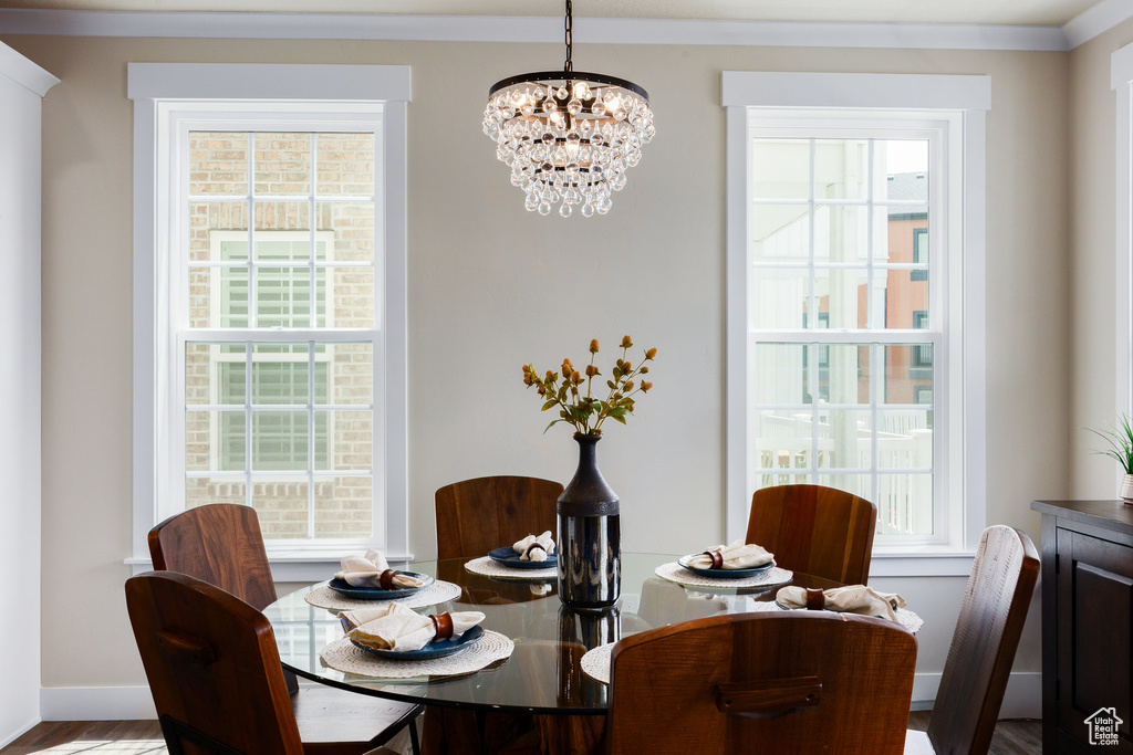 Dining room featuring a chandelier, healthy amount of natural light, and ornamental molding