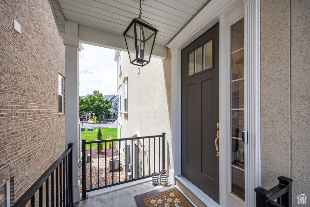 Property entrance featuring covered porch and stucco siding