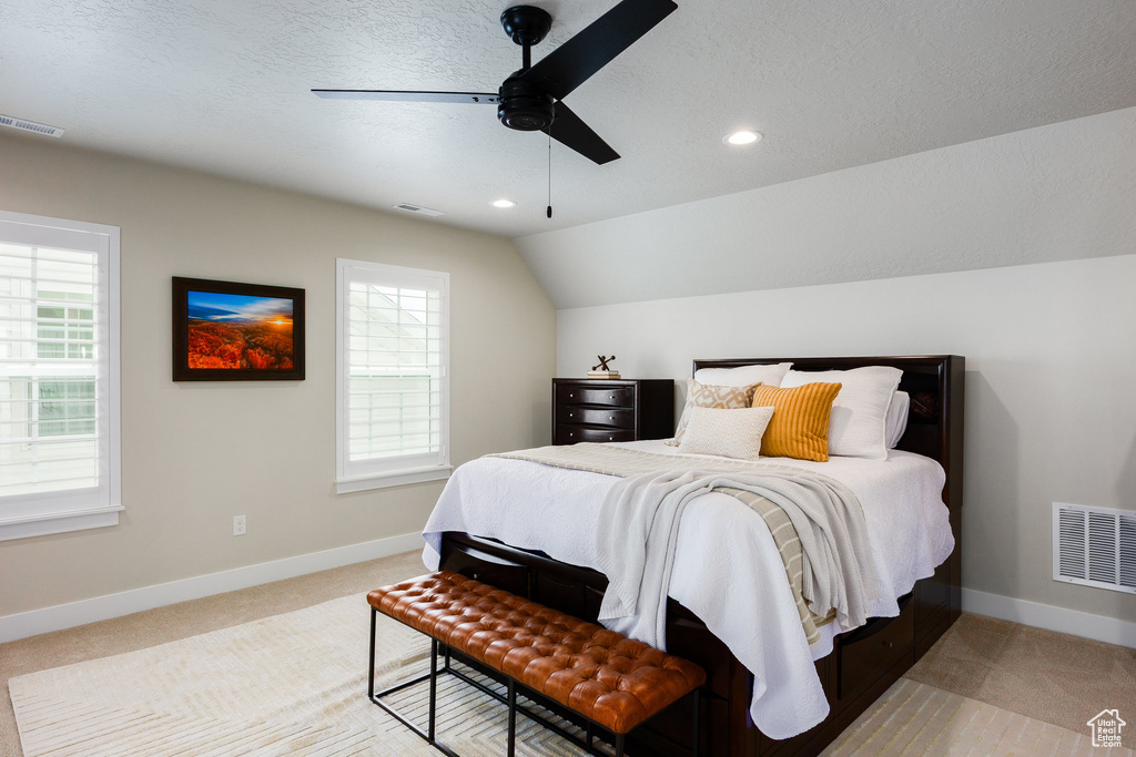 Bedroom with multiple windows, light colored carpet, recessed lighting, vaulted ceiling, and a ceiling fan