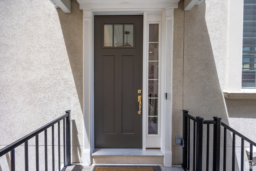 Doorway to property featuring stucco siding