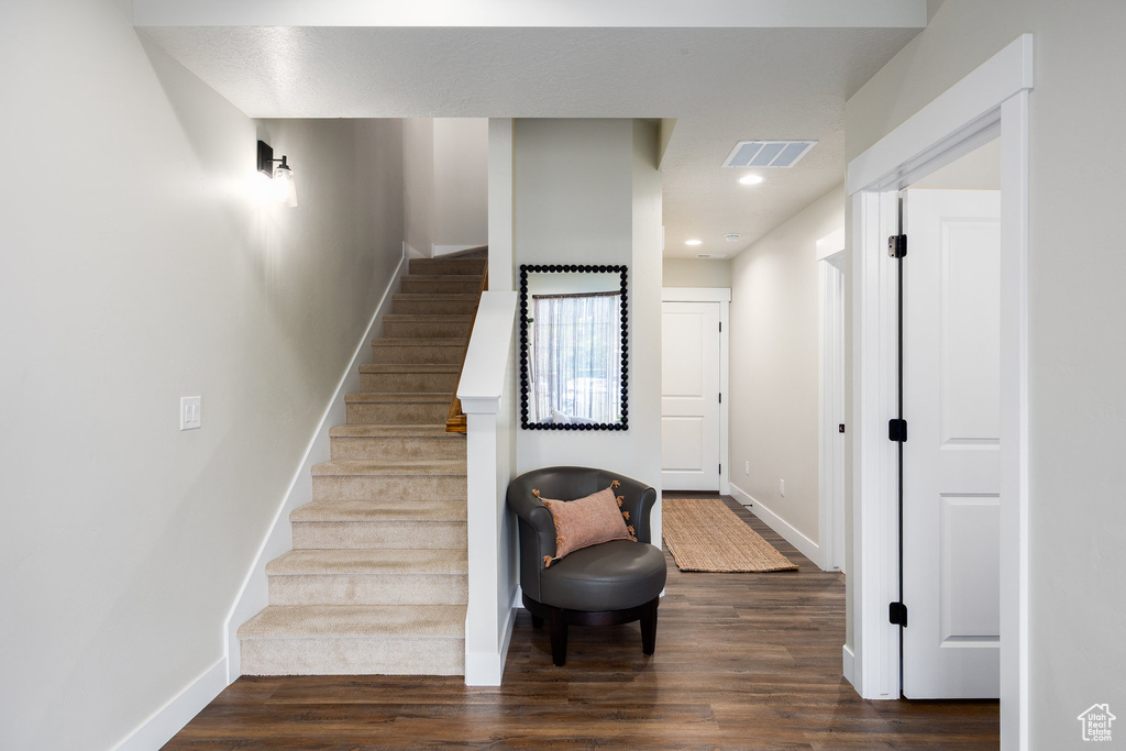Stairway with wood finished floors and recessed lighting