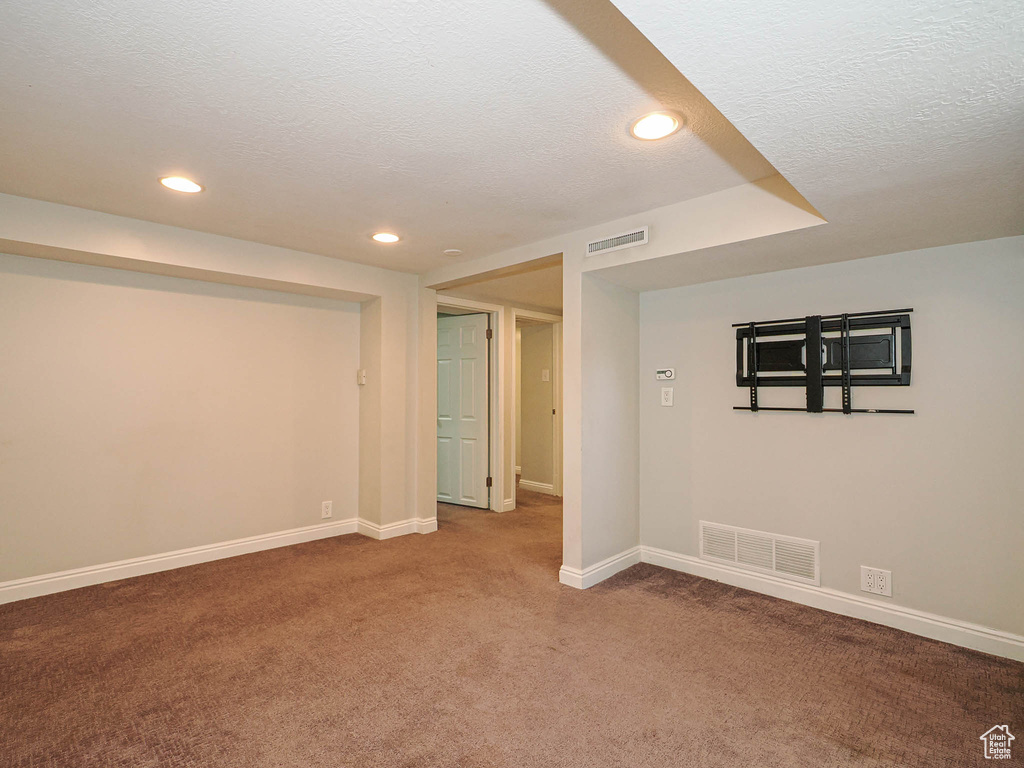Spare room with carpet, a textured ceiling, and recessed lighting