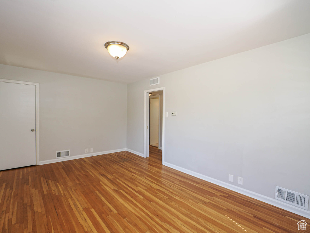 Spare room with hardwood / wood-style floors and baseboards