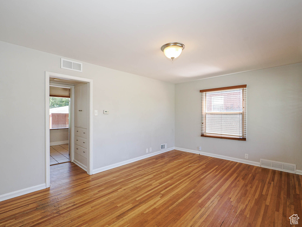 Unfurnished room featuring light wood-type flooring and plenty of natural light