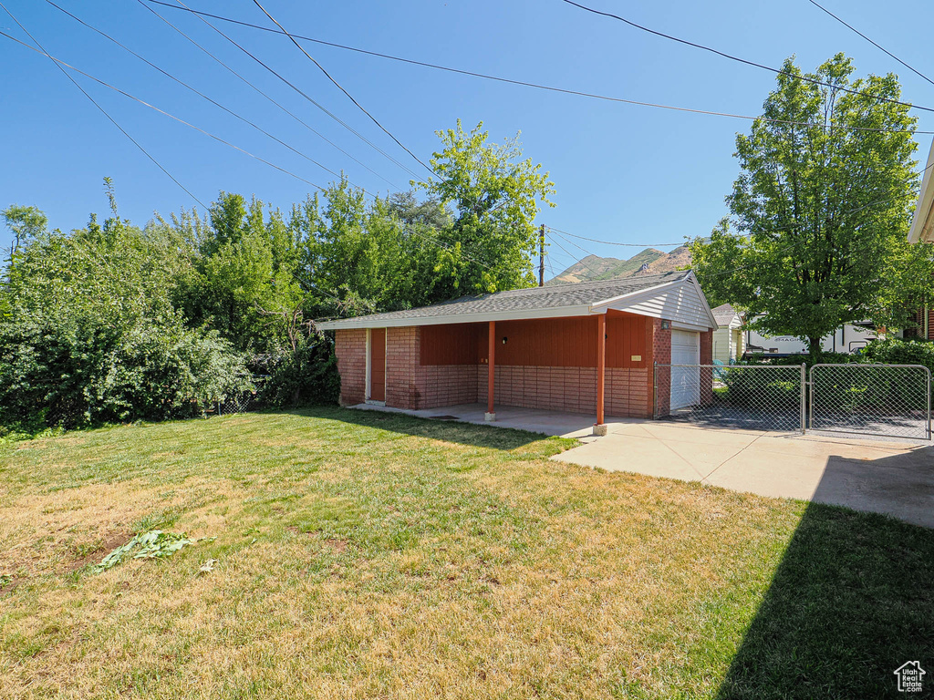 View of yard with a garage and an outbuilding