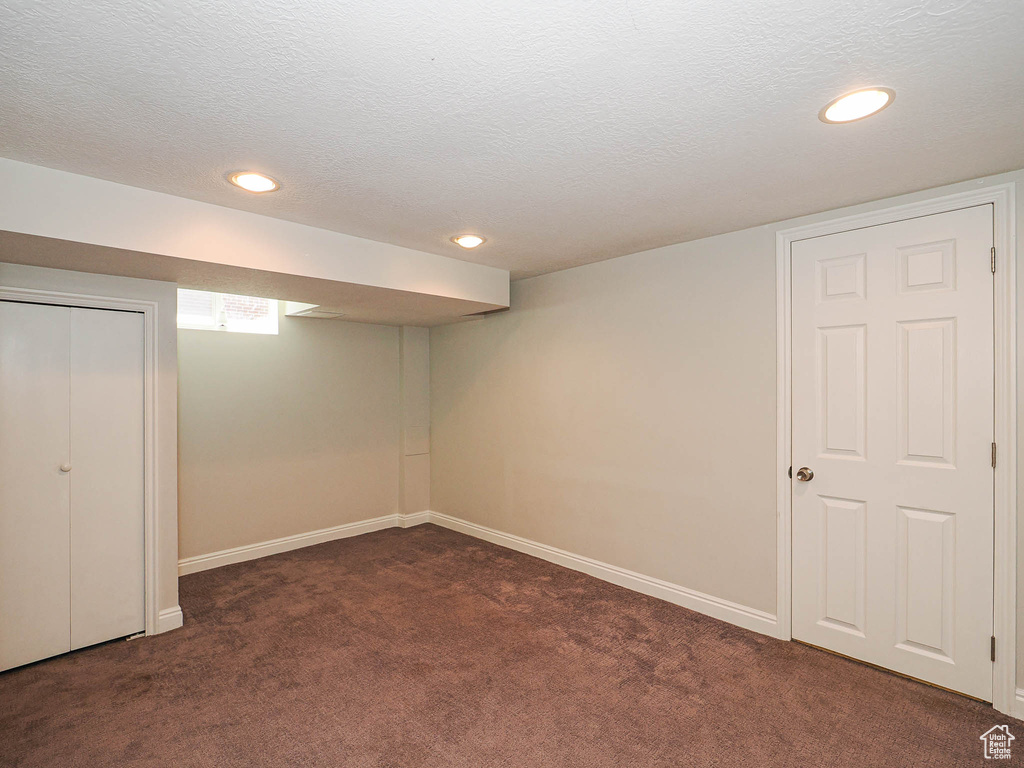 Finished basement featuring dark colored carpet, recessed lighting, and a textured ceiling