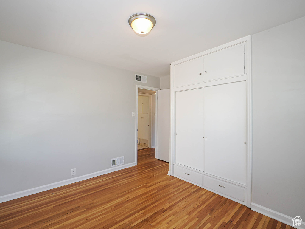 Unfurnished bedroom with light wood finished floors and a closet