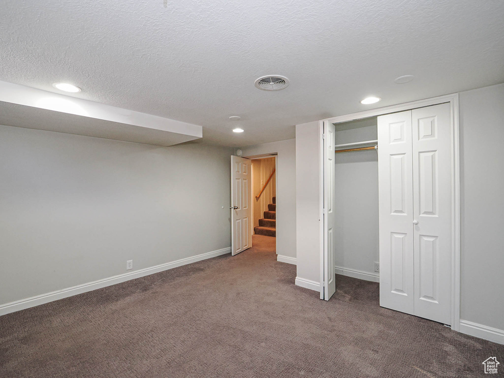 Unfurnished bedroom featuring carpet, recessed lighting, a textured ceiling, and a closet
