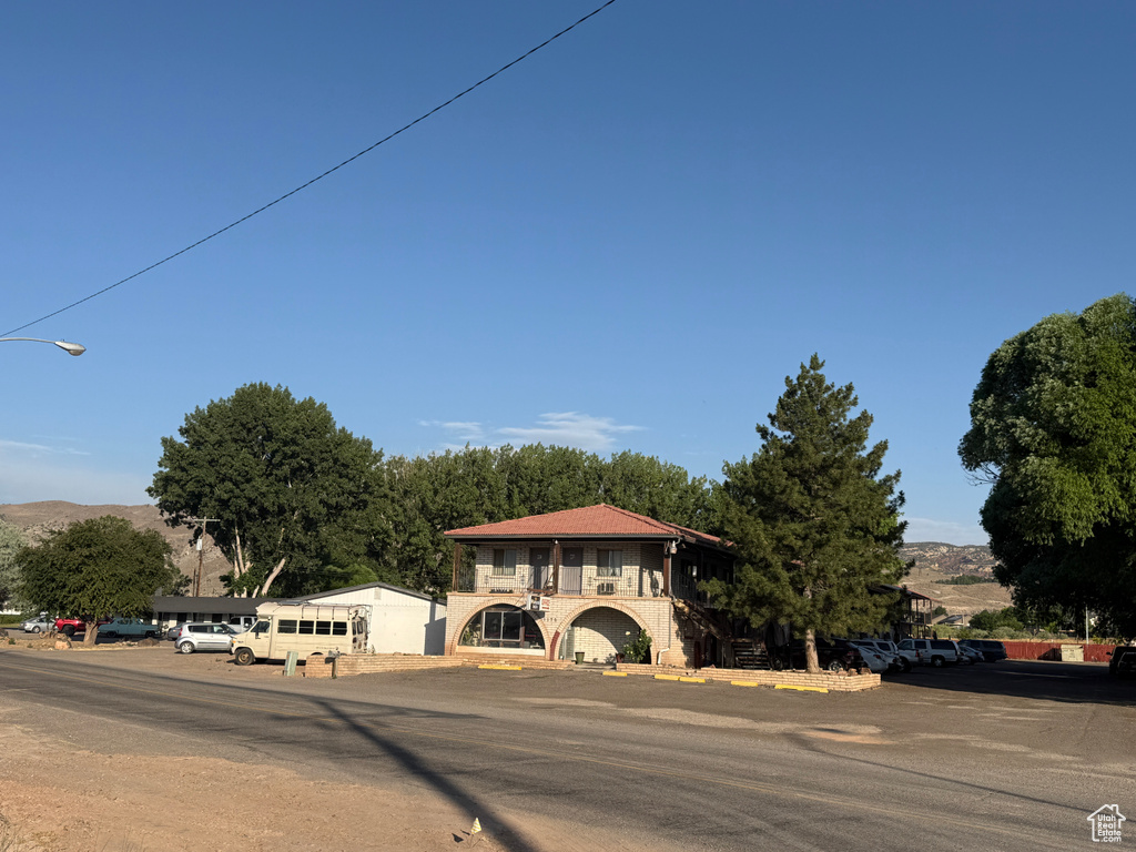 View of front of house with a balcony and uncovered parking