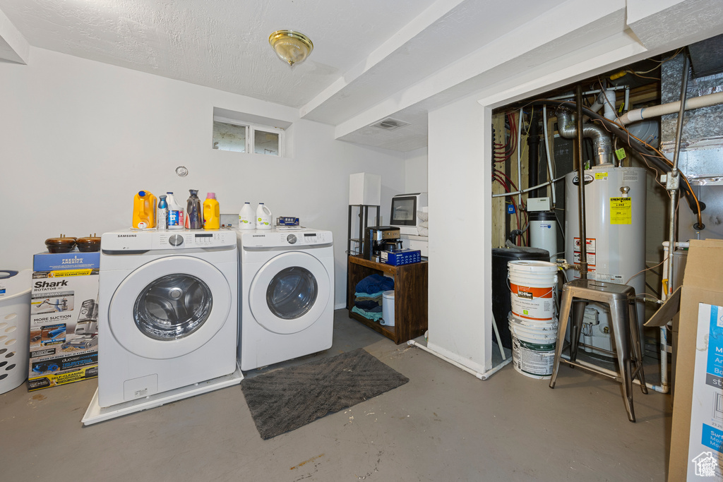 Laundry room featuring washer and clothes dryer and water heater