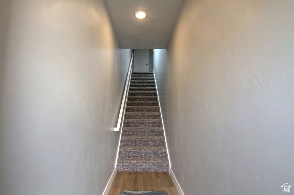 Staircase with baseboards and wood finished floors