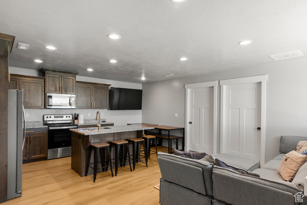Living area featuring light wood-style flooring and recessed lighting