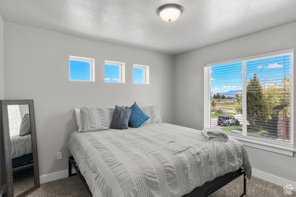 Bedroom featuring carpet and baseboards
