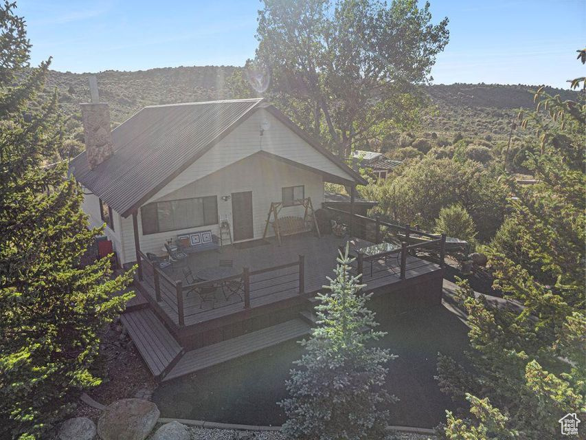 Rear view of house with a chimney and a deck