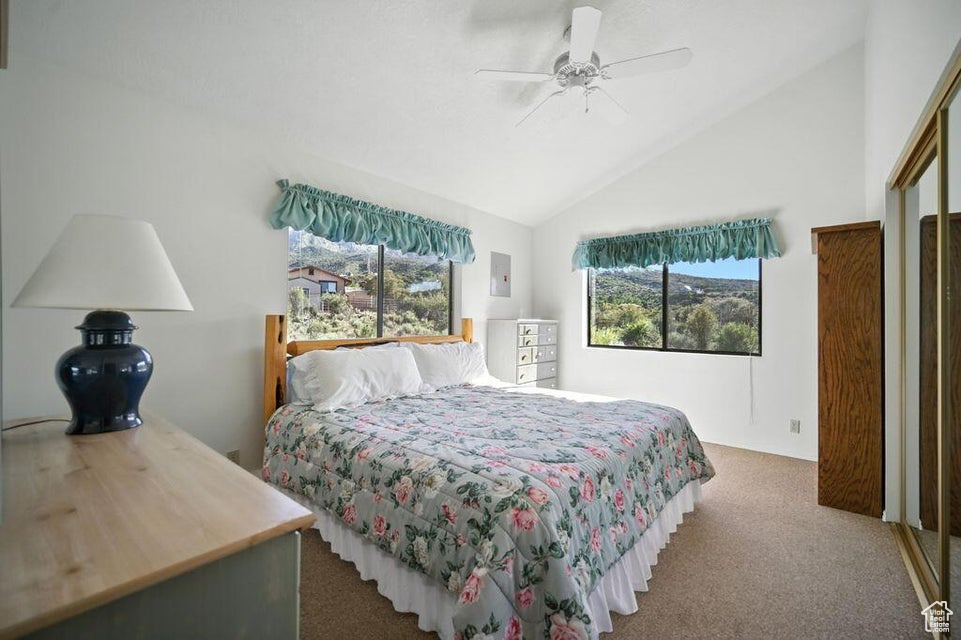 Bedroom with carpet floors, high vaulted ceiling, and a ceiling fan