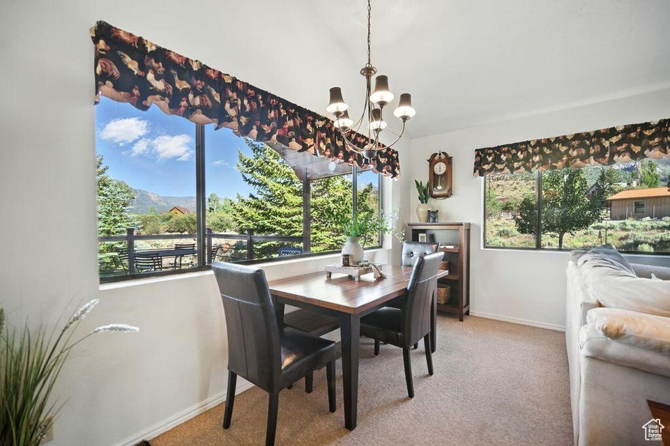 Dining space with a chandelier and carpet flooring