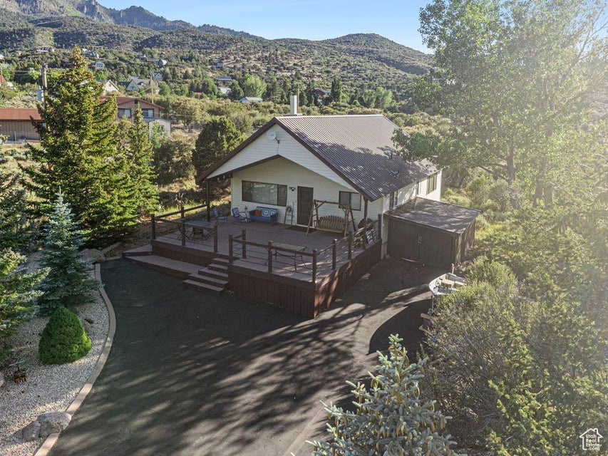 View of front of property with a deck with mountain view and a metal roof