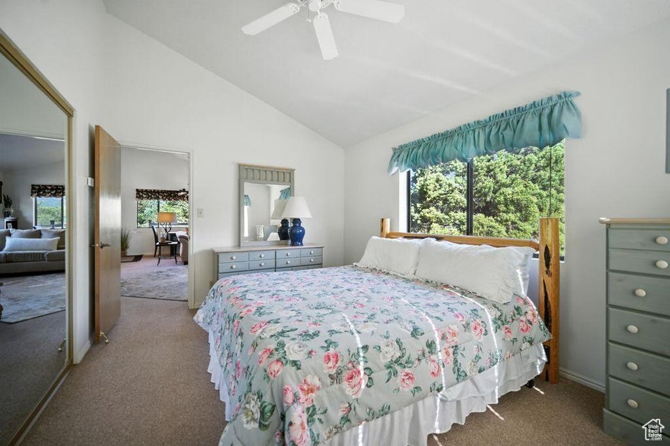 Bedroom featuring carpet floors, lofted ceiling, and a ceiling fan